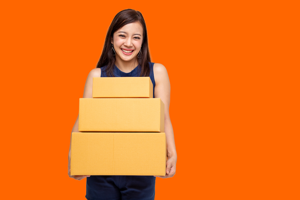 Photo of young lady with moving boxes